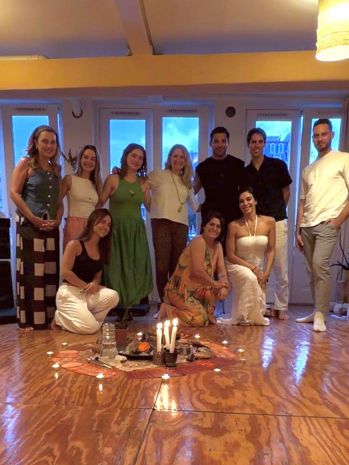 Participantes ao redor de um altar com velas acesas, ao fim de um encontro