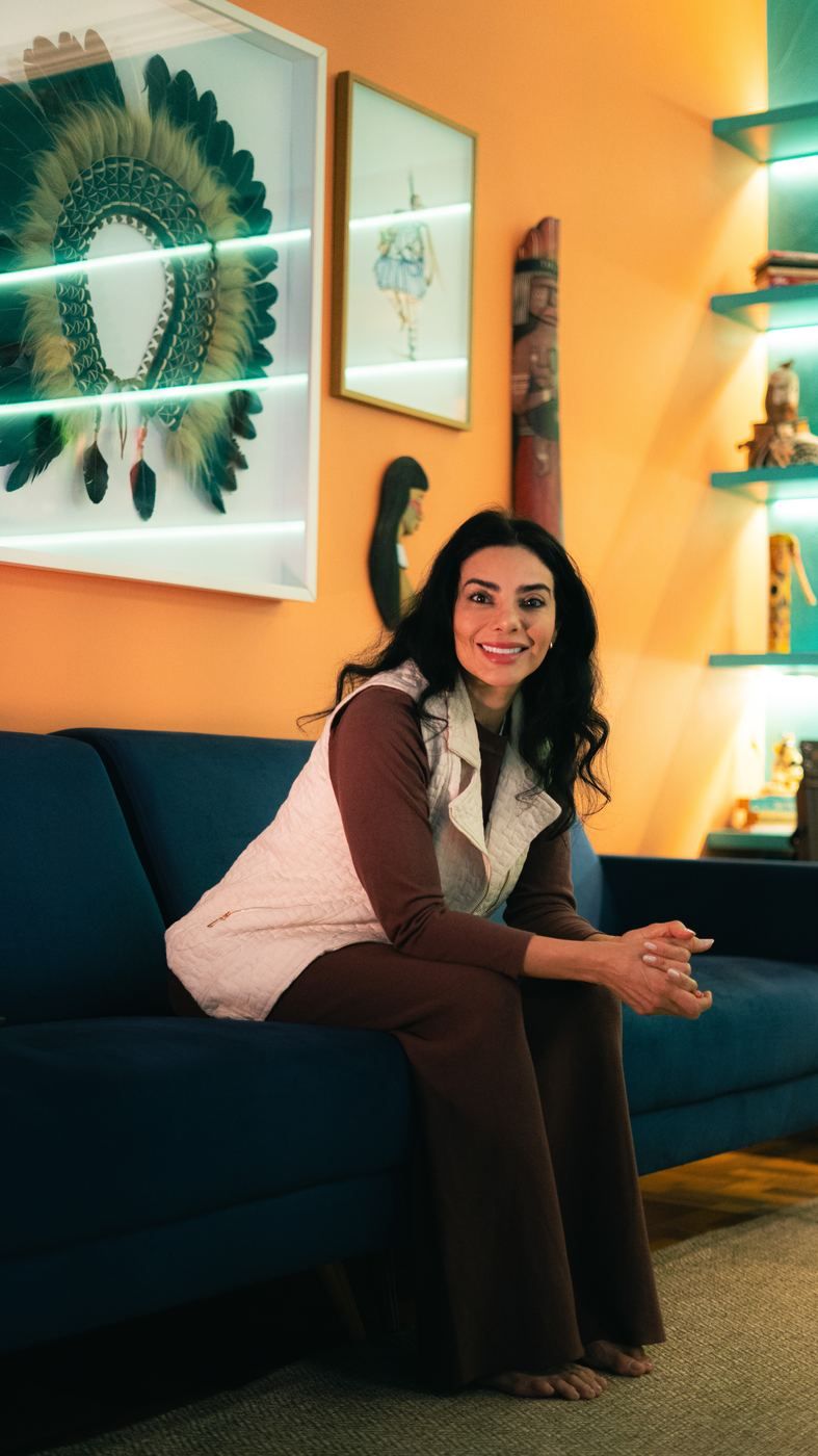 Elini Maria sorrindo, sentada em um sofá